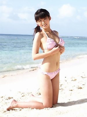 Sweet busty gravure chick having fun at the beach in her bikini